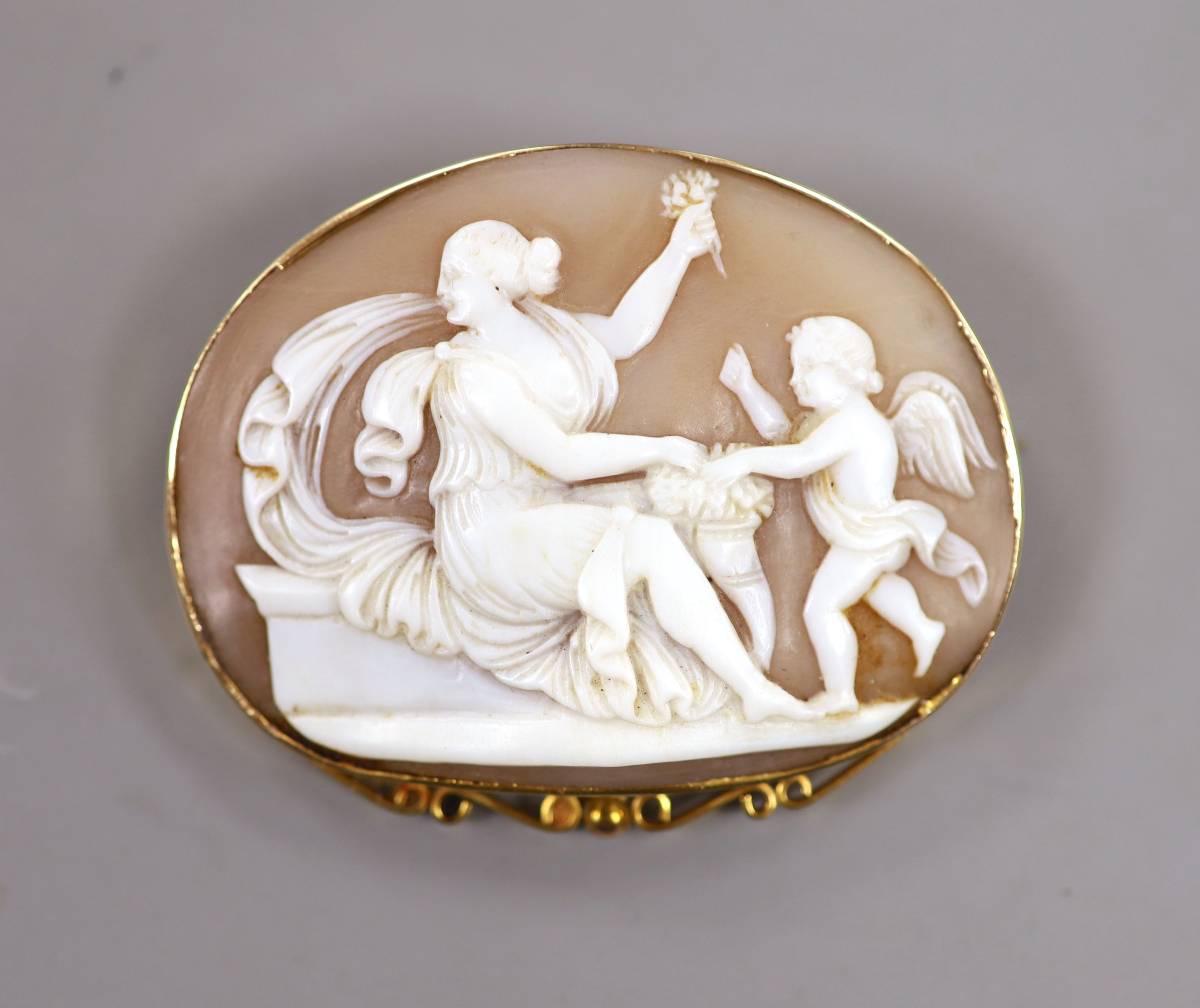 A 9ct mounted oval cameo brooch, carved with Cupid & Psyche, 60mm, gross weight 17.9 grams.